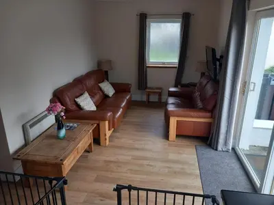 a living room with couches and a coffee table at The WEE HOUSE Balvicar Isle of Seil in Balvicar