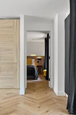 a bedroom with a bed and a wooden floor at Peterswell Holiday Cottage in Houston