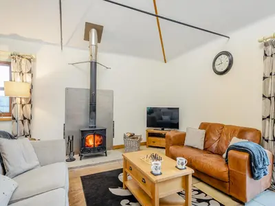 a living room with a couch and a fireplace at South Steading in West Kilbride