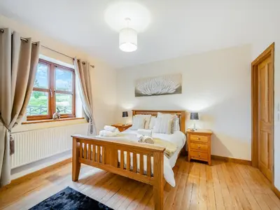 a bedroom with a large bed and a window at South Steading in West Kilbride