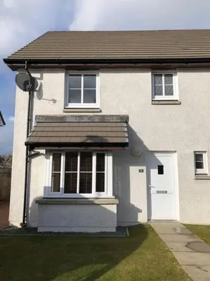 a white house with a window and a door at Beautiful cosy 2-bedroom entire house in Connel, near Oban in Connel