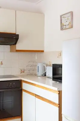 a kitchen with white cabinets and a black appliance at Executive Apartment By Inverkeithing Train Station in Fife