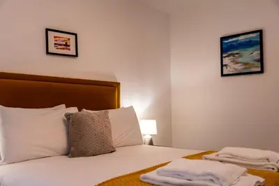 a bedroom with a bed with two towels on it at Dalwhinnie Apartment in Oban