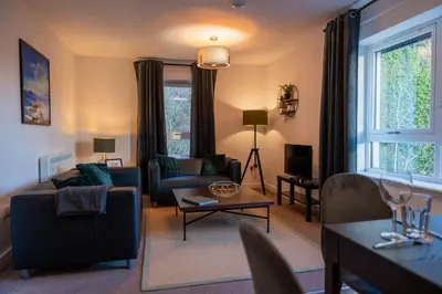 a living room with a couch and a table at Dalwhinnie Apartment in Oban