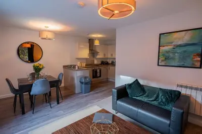 a living room and kitchen with a couch and a table at Tobermory Apartment in Oban
