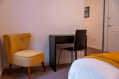 a bedroom with a desk and a chair and a bed at Tobermory Apartment in Oban