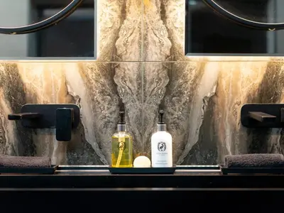 two bottles of soap sitting on a bathroom sink at Luxury Romantic West-End Apartment With Jacuzzi Spa Bath in Edinburgh