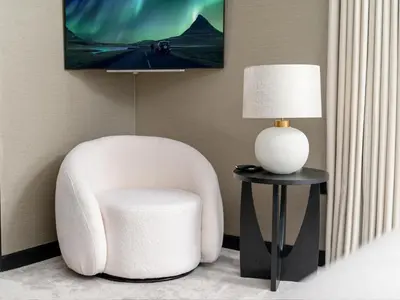 a white chair sitting next to a table with a lamp at Luxury Romantic West-End Apartment With Jacuzzi Spa Bath in Edinburgh