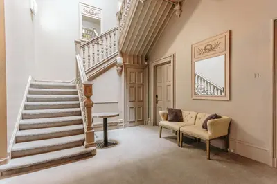 a living room with stairs and a couch at Murrayfield Hotel in Edinburgh