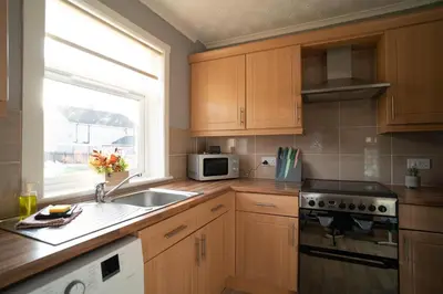 a kitchen with wooden cabinets and a sink and a window at Darmeid House in Hartwood