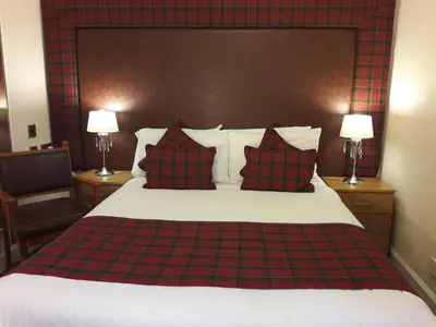 a bedroom with a bed with red and black pillows at Argyll Hotel in Glasgow