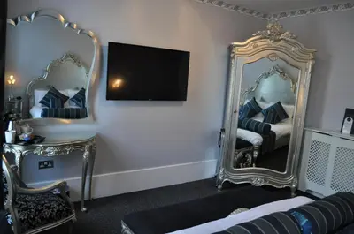 a room with two mirrors and a bed and a tv at Argyll Hotel in Glasgow
