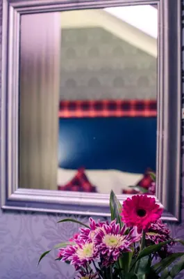 a vase of flowers in front of a mirror at Argyll Hotel in Glasgow