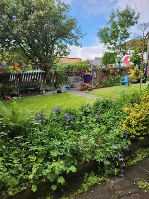 a garden with flowers and a bench in a yard at Largs holiday flat in Largs