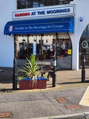 a restaurant with a table and a blue awning at Largs holiday flat in Largs