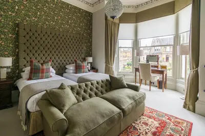 a bedroom with two beds and a couch at The Roseate Edinburgh - Small Luxury Hotels of the World in Edinburgh