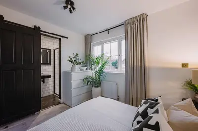 a bedroom with a bed and a window and plants at SleepLuxury ApartHOUSE in Glasgow