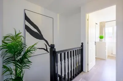 a hallway with a staircase and a potted plant at SleepLuxury ApartHOUSE in Glasgow