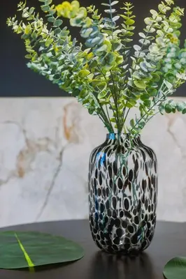 a black and white vase with flowers in it at SleepLuxury ApartHOUSE in Glasgow