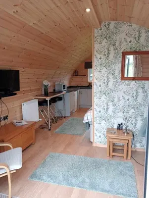 a room with a kitchen and a living room at The Galloway Steading - The Herons Nest, secure garden and with Hot Tub and Fire Pit in Glenluce