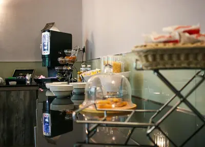 a kitchen with a glass counter with plates and dishes at Albion Hotel in Glasgow