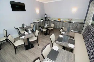 a restaurant with tables and chairs in a room at Albion Hotel in Glasgow