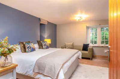 a bedroom with a bed and a couch and a window at The Jaw Barn in Milngavie