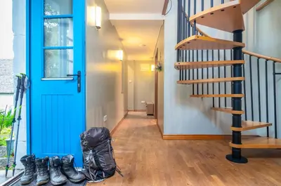 a hallway with a blue door and a pair of boots at The Jaw Barn in Milngavie