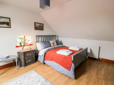 a bedroom with a bed with a red blanket at Shieldhill Farm House in Falkirk