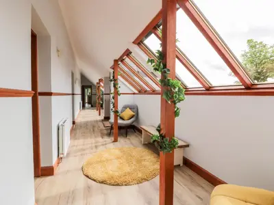 a hallway with a room with windows and a rug at Shieldhill Farm House in Falkirk