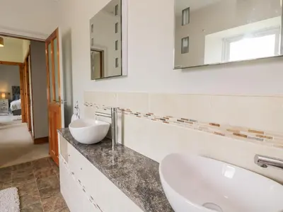 a bathroom with two sinks and a mirror at Shieldhill Farm House in Falkirk