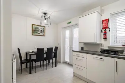 a kitchen and dining room with a table and chairs at Superb 3 Bed Home Away from Home in Glasgow, just off M8 with free parking in Steps