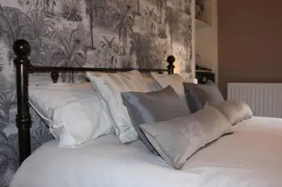 a bed with white sheets and pillows on it at Cameronian Apartment in Stirling
