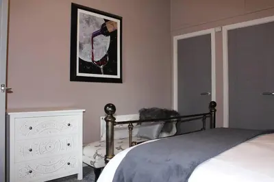 a bedroom with a bed and a painting on the wall at Cameronian Apartment in Stirling
