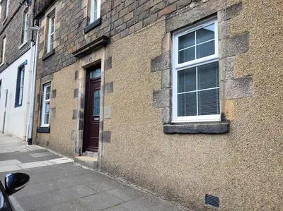 a brick building with a window and a door at Cameronian Apartment in Stirling