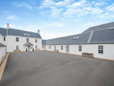 a large white building with a parking lot at The Byre - Uk45343 in Ayr