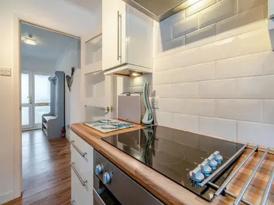 a kitchen with white walls and a counter top at Crarae in Corrie