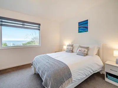 a white bedroom with a bed and a window at Crarae in Corrie