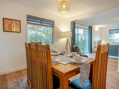 a dining room with a wooden table and chairs at Crarae in Corrie