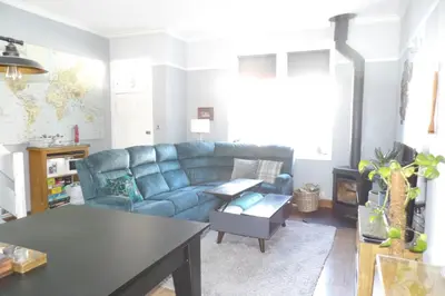 a living room with a blue couch and a table at Aigas in Glasgow