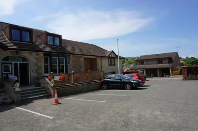 a car parked in a parking lot in front of a house at Boreland Lodge Hotel in Inverkeithing
