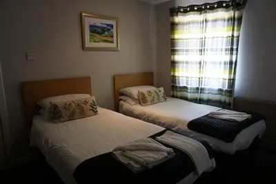 two twin beds in a room with a window at Boreland Lodge Hotel in Inverkeithing