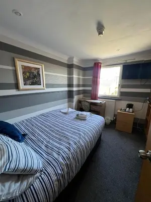 a bedroom with a bed with blue and white stripes at Boreland Lodge Hotel in Inverkeithing