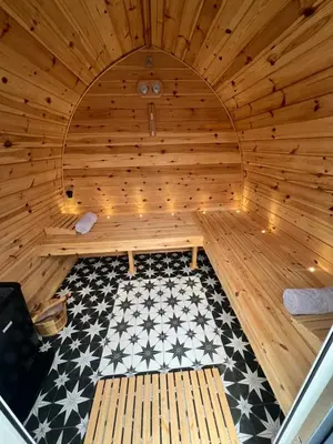 a large wooden sauna with a black and white floor at Loch View Luxury Pod in Connel