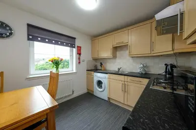 a kitchen with a washing machine and a window at Prime Duloch 2nd Floor Apartment by TBA in Fife