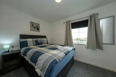 a bedroom with a bed and a window at Prime Duloch 2nd Floor Apartment by TBA in Fife