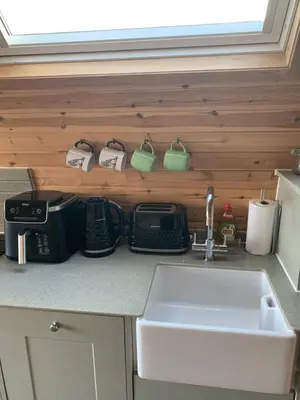 a kitchen counter with a sink next to a counter top at Tawny Owl Pod with Hot Tub in Oban