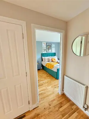 a bedroom with a bed and a mirror at Modern 5 Bedroom Townhouse with Free Parking in Glasgow
