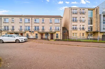 a white car parked in front of a building at Modern 5 Bedroom Townhouse with Free Parking in Glasgow
