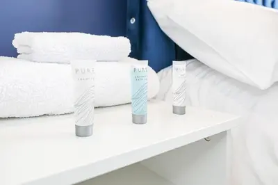 two toothbrushes sitting on a shelf next to a bed at Doralan in Bishopbriggs